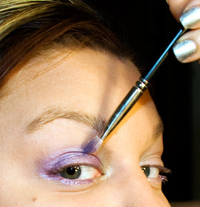 Applying lavender eyeshadow to my eyelid. 